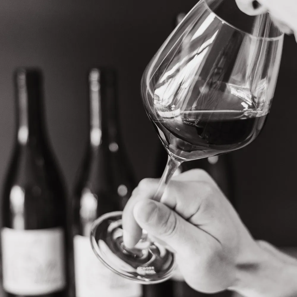 Dégustation d'un verre de vin rouge à La Cave Nectar, photo noir et blanc