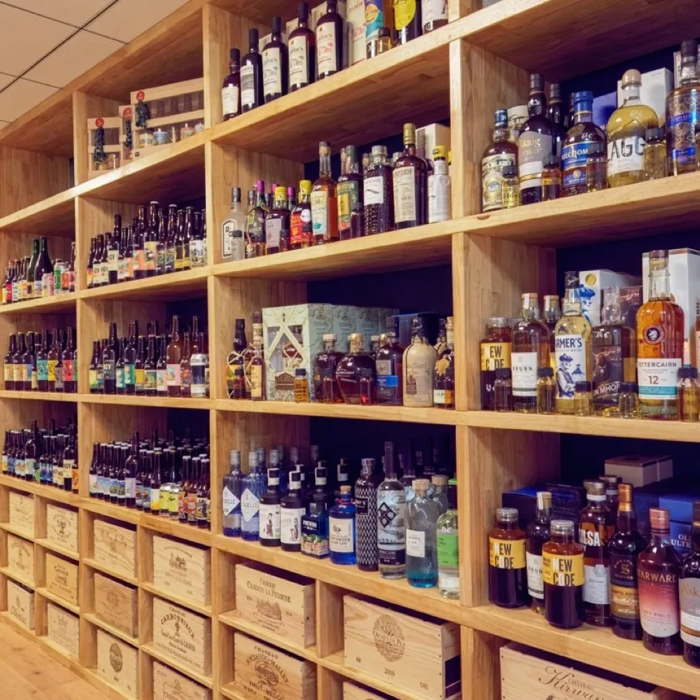 Rayon spiritueux et bières artisanales de La Cave Nectar sur étagères en bois
