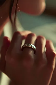 Visuel IA bijou : gros plan sur une bague en argent portee a la main, lumiere naturelle chaude